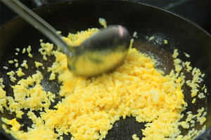 大火加熱炒鍋，再入油，燒到四至五成熱時倒入雞蛋液，在未凝結(jié)之前，加米飯煸炒，不停翻炒并用鍋鏟將成塊的米飯碾開、撥散。