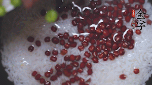 將炒好的食材和大米、紅豆一起放進(jìn)電飯鍋煮。