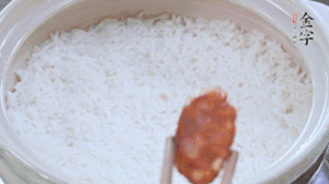 煮開后轉(zhuǎn)小火，當(dāng)米飯出現(xiàn)小孔時，鋪上金字麻辣香腸。