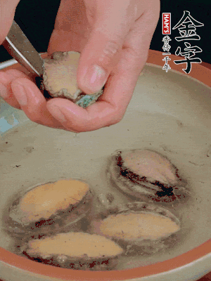 鮑魚加鹽、清水浸泡，用勺子挖出鮑魚肉。