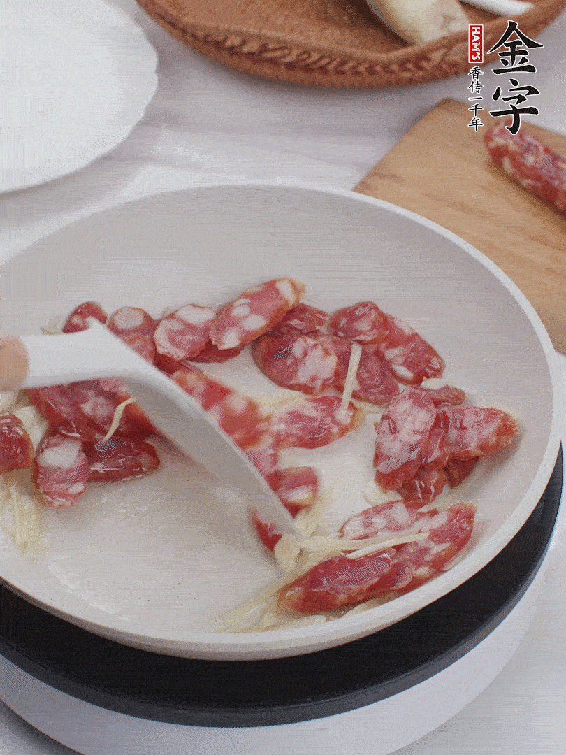 油溫3成熱時，下姜絲、蒜片、香腸炒出油脂。