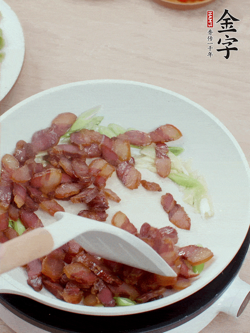 鍋中少許油，姜、蒜白爆香，下臘肉煸出油脂。