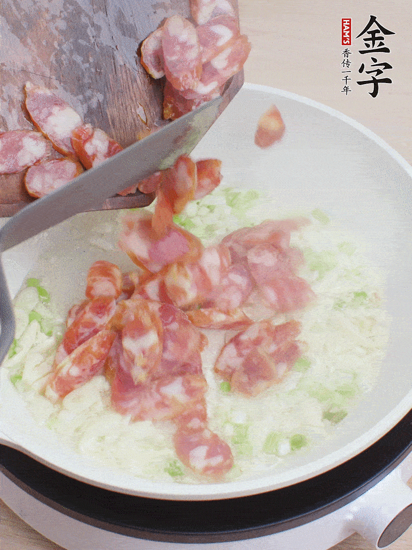 油5成熱，蒜末、蔥白爆香，下香腸炒出香味。