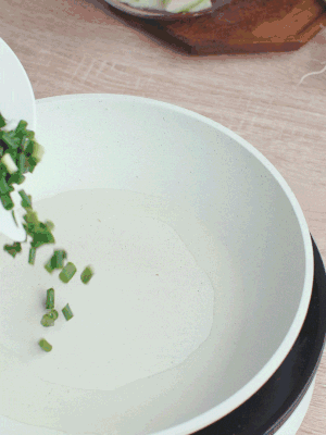 熱油下臘肉、蔥花煸炒，再下西葫蘆。