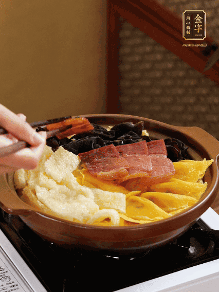 砂鍋底部鋪上娃娃菜，依次擺上肉皮、蛋餃、黑木耳、火腿